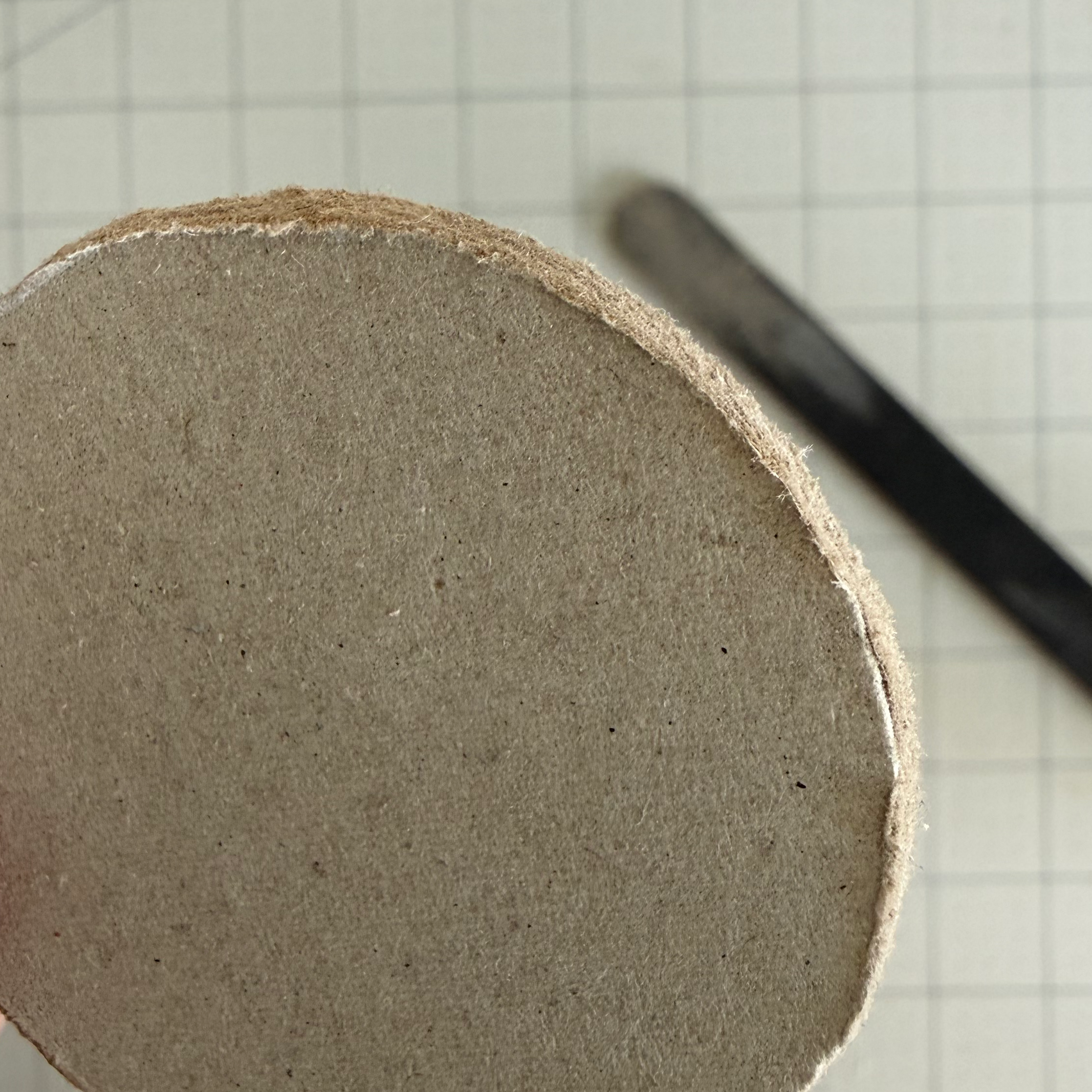Close view of a chipboard circle edge being smoothed