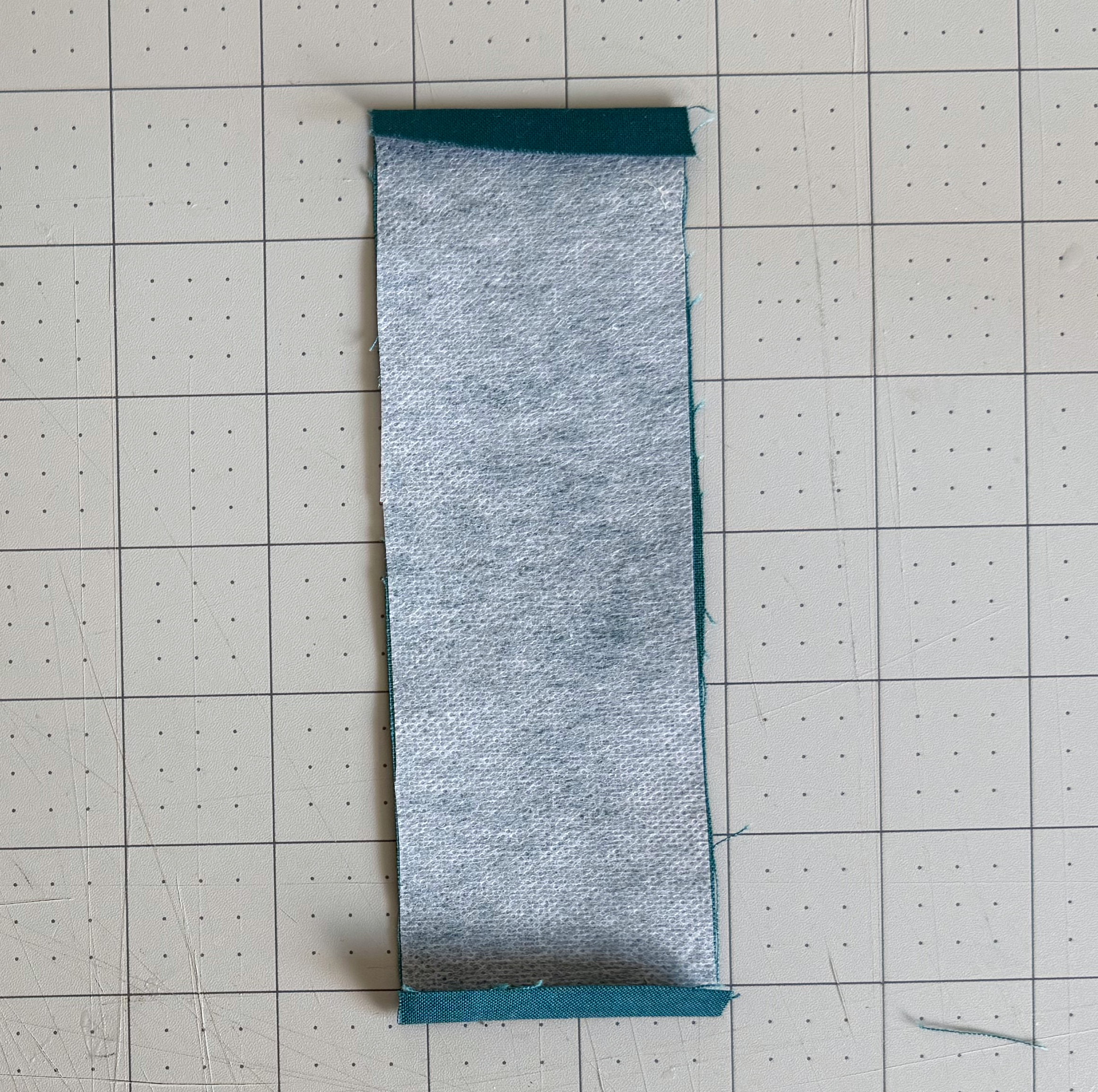 Top and bottom fabric edges ironed down over the fusible interfacing