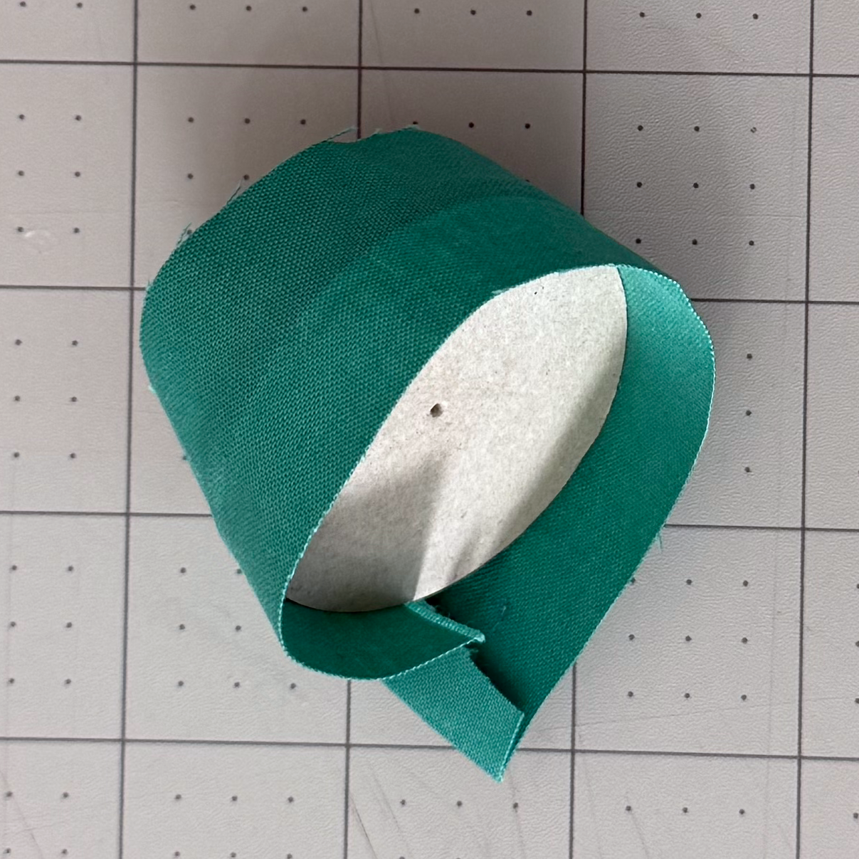 Fabric strip being wrapped around a curved chipboard edge