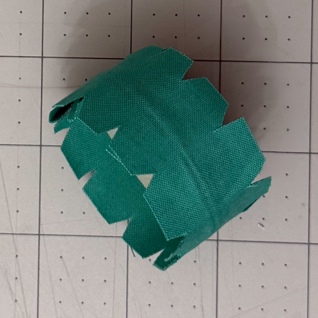 Triangular notches cut into the fabric around a chipboard circle