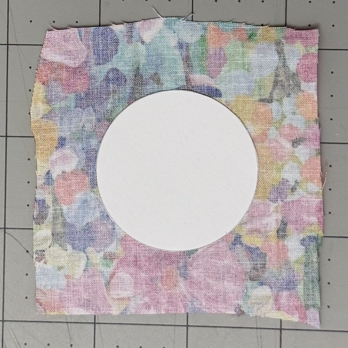 Circular cardstock lining card centered on the wrong side of fabric