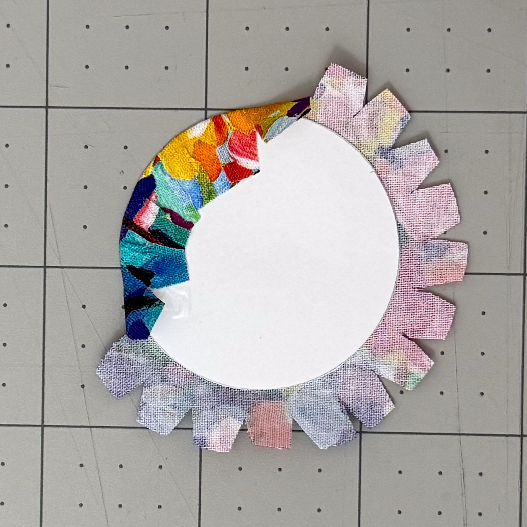 First fabric tabs folded over a circular cardstock lining card