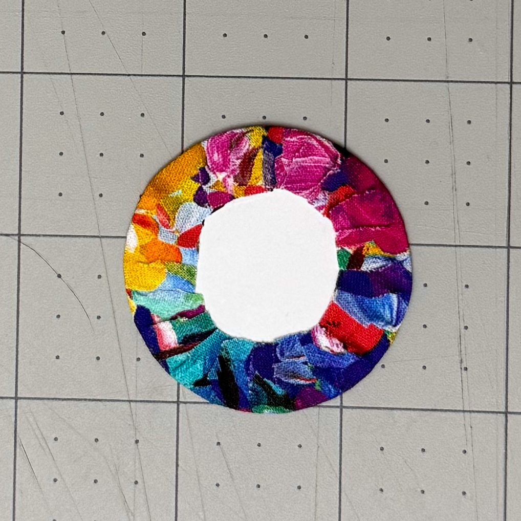 Fabric tabs folded around most of a circular lining card